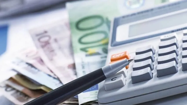 Στυλό και αριθμομηχανή πάνω σε χαρτονομίσματα ευρώ