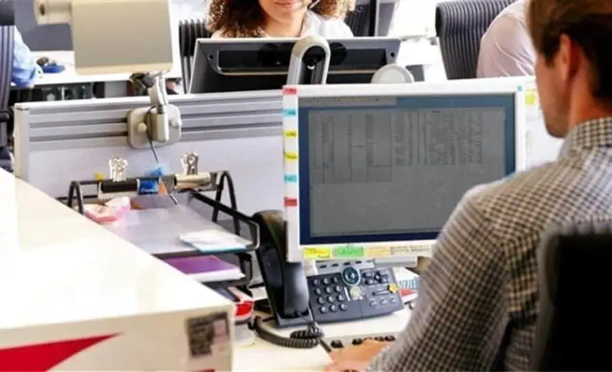 Εργαζόμενοι σε γραφείο μπροστά σε οθόνες υπολογιστών