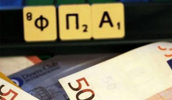 Γράμματα που σχηματίζουν τη λέξη ΦΠΑ πάνω σε χαρτονομίσματα ευρώ