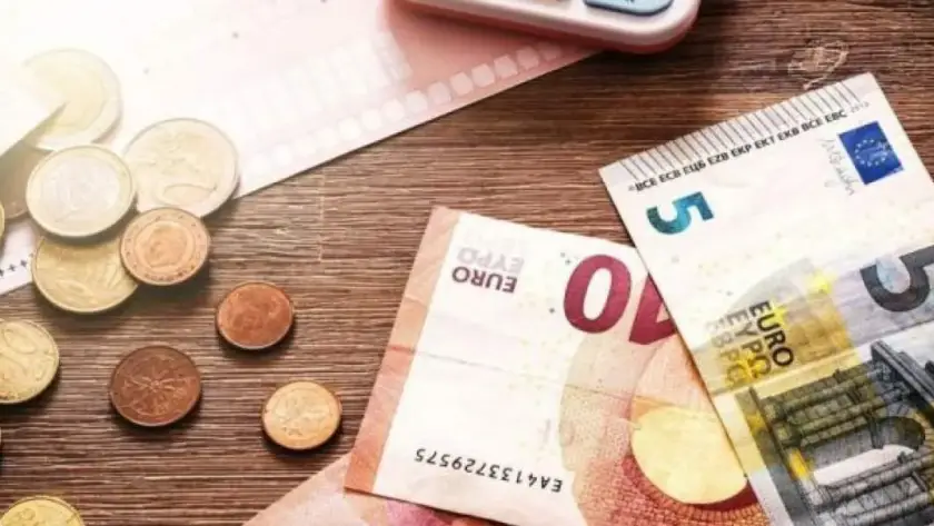 Χαρτονομίσματα και κέρματα ευρώ σε ξύλινο τραπέζι