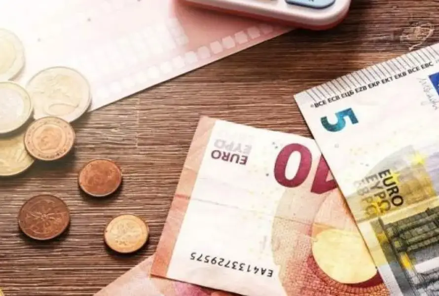 Χαρτονομίσματα και κέρματα ευρώ σε ξύλινο τραπέζι